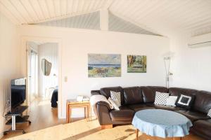 a living room with a leather couch and a table at 14234-Grevinge-Strandmosen-11 in Grevinge