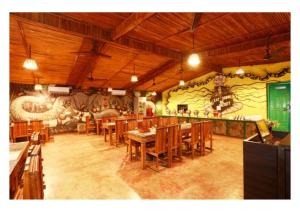 a restaurant with wooden tables and a wall with graffiti at Corbett Soho Resort in Haldwāni