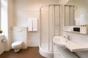 a bathroom with a shower and a toilet and a sink at Metropolitan Old Town Hotel - Czech Leading Hotels in Prague
