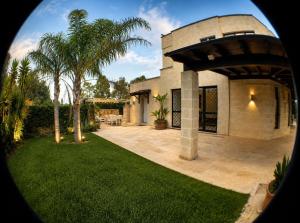 a house with a palm tree in front of it at OLYMPUS PARK amnesia in Mesagne