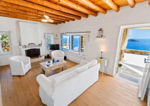 a living room with white furniture and a view of the ocean at "GOLDEN SUNSET VILLA" 3-BDR, Breathtaking Views in Batsi