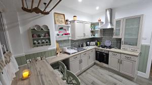 a kitchen with white cabinets and a wooden table at Twisted Chimney View in Alford