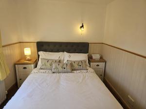 a bedroom with a white bed with two night stands at Twisted Chimney View in Alford
