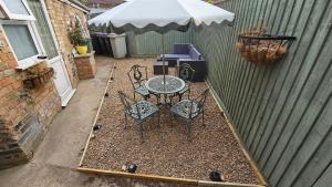 a patio with a table and chairs and an umbrella at Twisted Chimney View in Alford