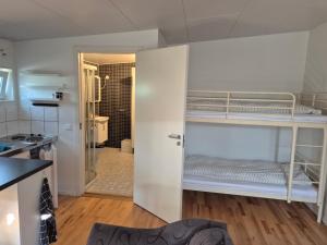 a room with two bunk beds and a kitchen at Den fräscha lägenheten in Ängelholm