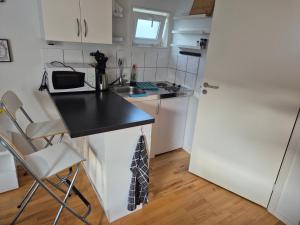 a small kitchen with a counter and a refrigerator at Den fräscha lägenheten in Ängelholm