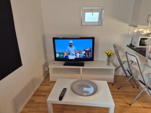 a living room with a flat screen tv on a table at Den fräscha lägenheten in Ängelholm