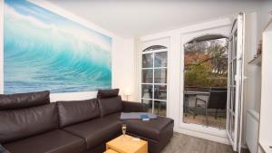 a living room with a couch and a large painting at Sonnensegler - Bade- & Saunawelt täglich inklusive in Baabe