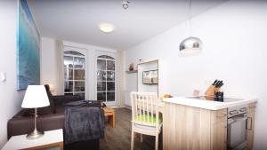 a kitchen and a living room with a couch at Sonnensegler - Bade- & Saunawelt täglich inklusive in Baabe +9 photos