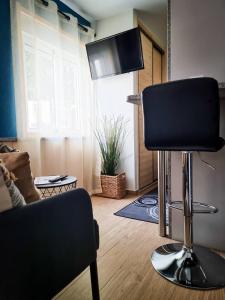 a living room with a chair and a flat screen tv at Cantinho do Chico in Vila Nova de Gaia