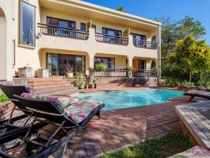 a house with a swimming pool and two lounge chairs at Serenity Place B&B and Conference, wedding venue in Durban