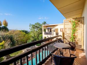 a balcony with a stool and a table on a porch at Serenity Place B&B and Conference, wedding venue in Durban
