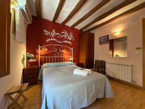 a bedroom with a large bed with a red wall at Entrefrutales · Casa Rural entre Árboles y Aromas in La Vilueña
