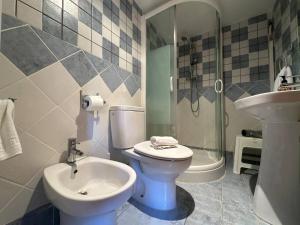 a bathroom with a toilet and a sink and a shower at Entrefrutales · Casa Rural entre Árboles y Aromas in La Vilueña +41 photos