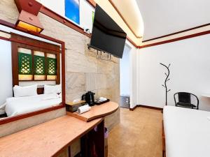 a bedroom with a bed and a tv in a room at Chalet De Palm Resort Hatyai in Hat Yai