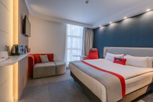 a hotel room with a bed and a chair at Holiday Inn Express - Yerevan by IHG in Yerevan