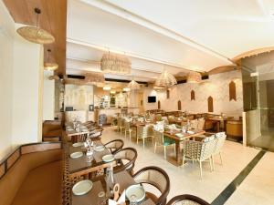 a restaurant with tables and chairs in a room at Palette Hotel by CheckIn Amritsar, Airport Road in Amritsar