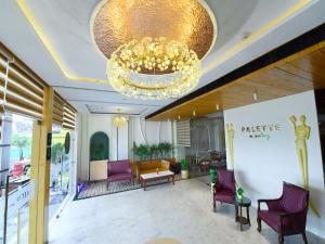 a lobby with purple chairs and a chandelier at Palette Hotel by CheckIn Amritsar, Airport Road in Amritsar