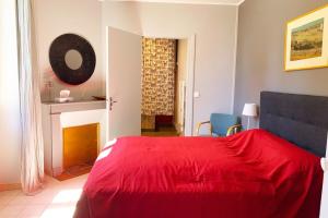 a bedroom with a red bed and a fireplace at Gite cosy 4 pers en vallée de la Creuse in Baraize +20 photos