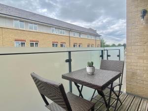 a table and chairs on a balcony with a plant at Your Space Apartments - Eden House in Cambridge