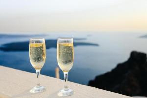 two glasses of champagne sitting on a ledge near the water at Donegal Oceanview Retreat in Drumaville +8 photos