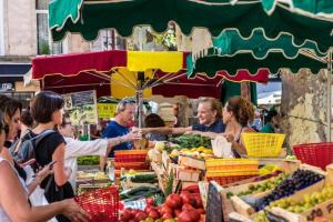 a group of people standing around a market with fruits and vegetables at Donegal Oceanview Retreat in Drumaville