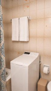 a small bathroom with a white washer and dryer at The Blue - Kythira in Kondoliánika +19 photos