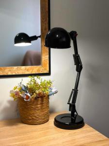 a black lamp sitting on a table next to a basket at Breeze Apartments Megara - Nest in Megara