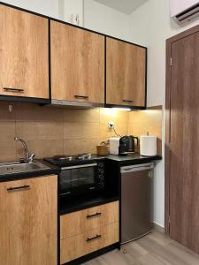 a kitchen with a sink and a microwave at Breeze Apartments Megara - Nest in Megara