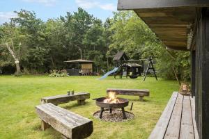 a fire pit with two benches and a playground at LF16124-Farso-Bjarkesvej-4 in Farsø