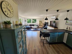 a kitchen and living room with a large clock on the wall at LF16124-Farso-Bjarkesvej-4 in Farsø