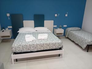 a bedroom with two beds and a blue wall at Terra e Cielo Rooms in Parghelia