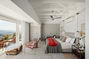 a bedroom with a bed and a balcony at The Lighthouse in Simonʼs Town