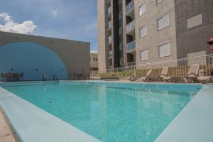 a large swimming pool with chairs and a building at Edifício Forte dos Lagos in Toledo