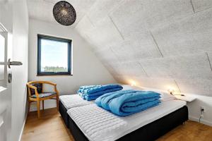 a bedroom with a bed with blue pillows on it at 0431-Romo-Vestergade-333 in Høm