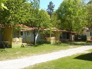 Cabaña con mesa y sillas en el patio en Camping Frédéric Mistral, en Castellane