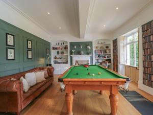 a living room with a pool table and a couch at Cotswold House in Moreton in Marsh