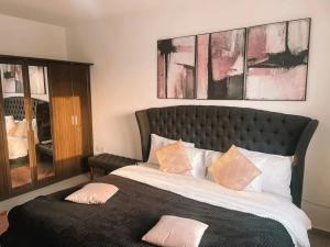 a bedroom with a large bed with pink pillows at Tcc - Skysuites in Accra +46 photos