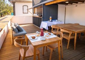 a patio with wooden tables and chairs on a balcony at L'Escale Bleue in Saint-Leu