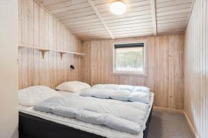 a bedroom with a bed in a wooden wall at 0011-Romo-Trinnesvej-9 in Høm