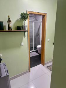 a bathroom with a toilet and a door with a window at AP2B Praia in Praia +4 photos