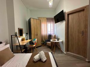 a room with a bed and a table and a door at Breeze Apartments Megara - Nest in Megara