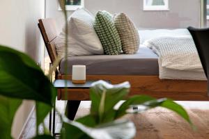 a living room with a bed with pillows and a table at Studio-Wohnung Lichtblick in Gersthofen +18 photos