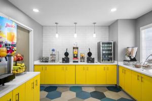 a kitchen with yellow cabinets and a yellow counter at Microtel Inn Georgetown - Lexington North in Georgetown