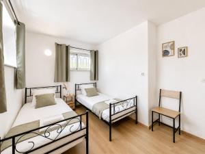 a bedroom with two beds and a chair at Le logis de Louze in Saint-Maurice-lʼExil