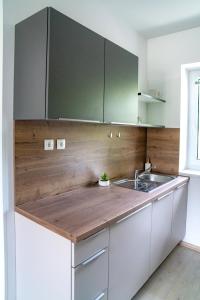 a kitchen with white cabinets and a wooden counter top at Prenočišča Dany in Dravograd