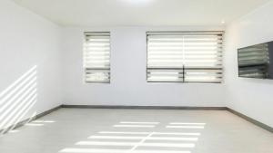 a room with white walls and windows with shadows on the floor at Yeosu Onueli Pension in Yeosu