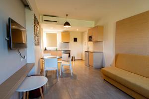a small apartment with a couch and a table and chairs at Eriphilly Studios & Apartments in Mythimna