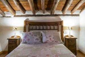 a bedroom with a large bed with two night stands at Casa Rural Abuelo Pedro in Cuerva +44 photos