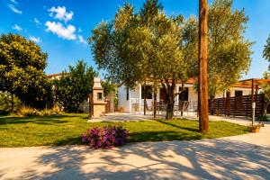 a house with a pole and flowers in the yard at Chrisella Villa in Skala Rachoniou